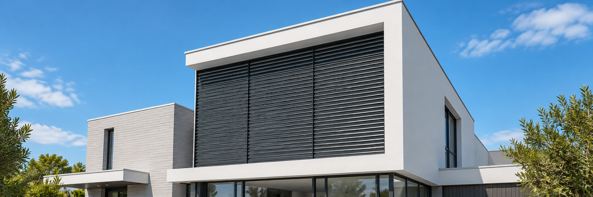 Charcoal aluminium fixed louvre shutters across three bays on a modern white home