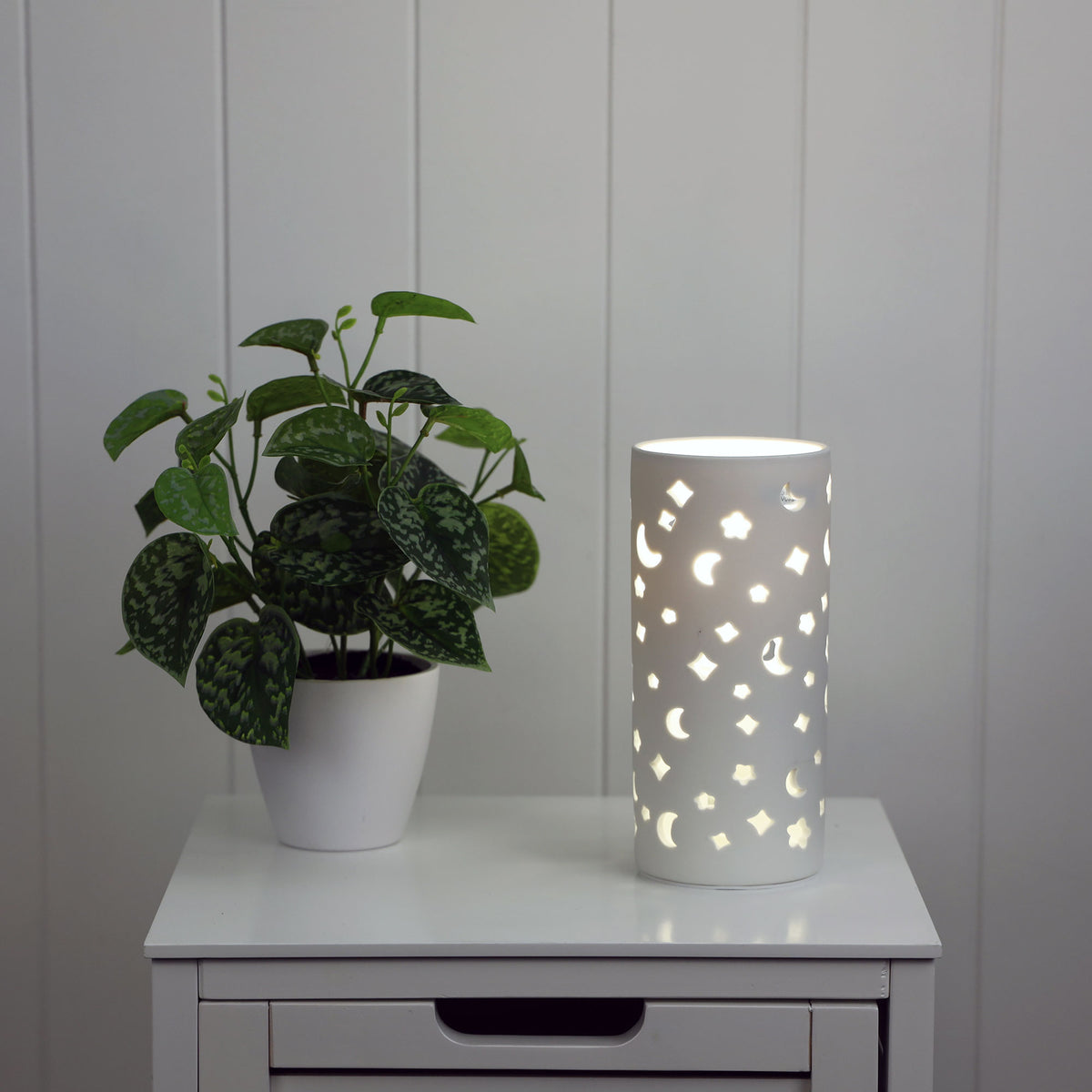 Diana Moon Ceramic lamp with moon and star pattern styled in a room