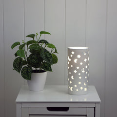Diana Moon Ceramic lamp with moon and star pattern styled in a room