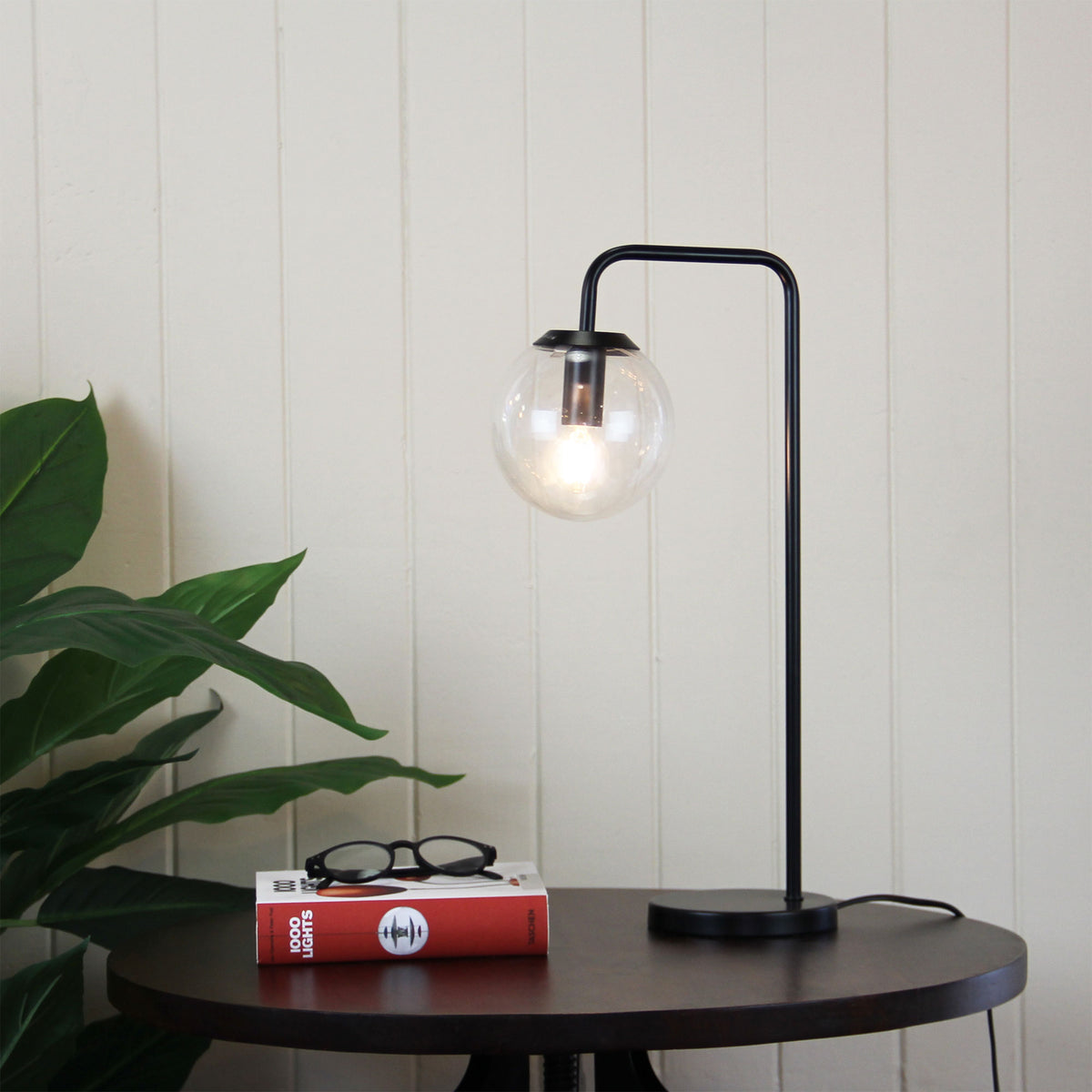 Newton Contemporary Clear Glass Lamp Black styled in a room